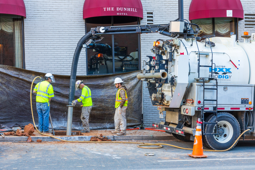 Professional technician using specialized equipment for underground utility locating to identify and map buried utility lines before excavation.